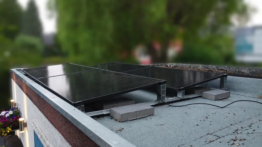 Vier schwarze Solarmodule auf einem Flachdach in Ahlen