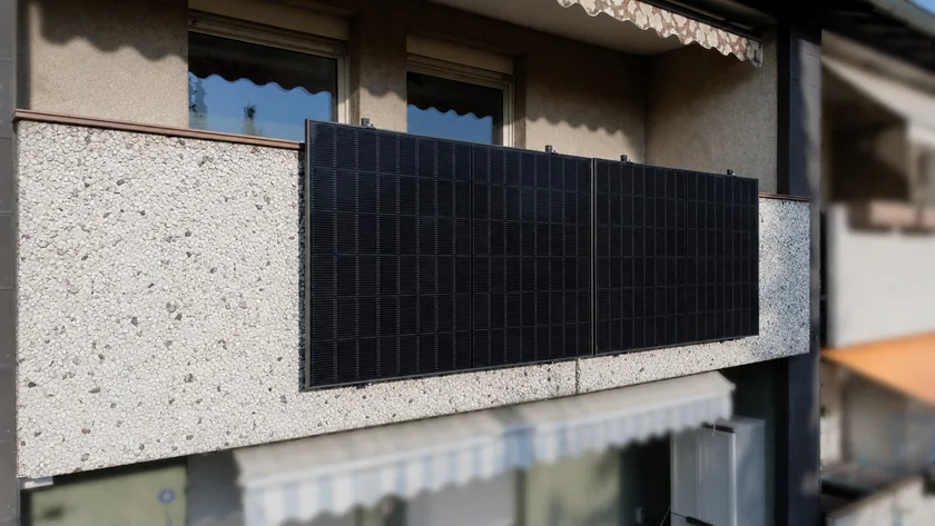 Zwei schwarze Solarmodule an einem Betonbalkon in Ahlen
